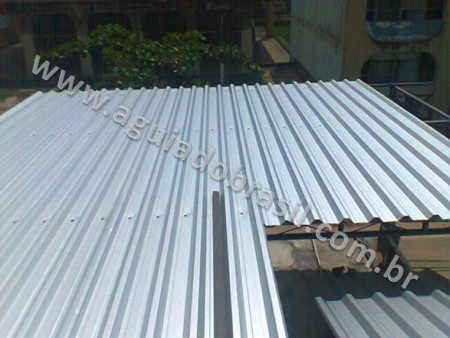 VISTA SUPERIOR DE COBERTURA DE TERRAÇO RESIDENCIAL, FASE DE FIXAÇÃO DE TELHAS, NOTE QUE SÃO APARAFUSADAS EM TODOS OS GOMOS DA TELHA DE AÇO GALVALUME.